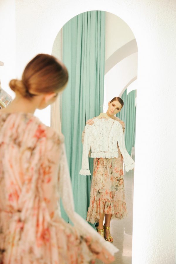 Kate Waterhouse looking in a mirror holding a Zimmermann top